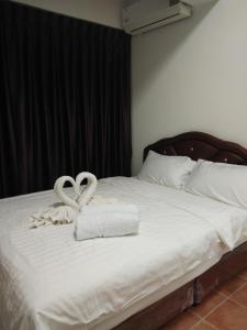 a bed with two swans shaped towels on it at Avatara condo B22 A in Mae Pim