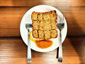 a plate of food with two forks on a table at Pride Home in Chandīgarh