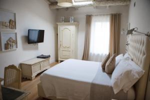 a bedroom with a white bed and a television at Misia Resort in Orvieto