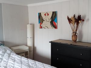 a bedroom with a dresser and a painting on the wall at Haus Marlene in Zell an der Mosel