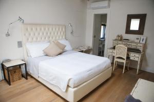 a bedroom with a large white bed and a desk at Misia Resort in Orvieto