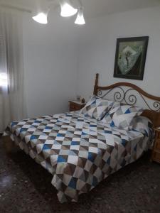 ルビエロス・デ・モラにあるLa Terraza-Rubielos de Moraのベッドルーム1室(チェック入りの毛布付きのベッド1台付)