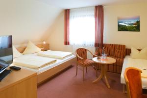 Habitación de hotel con cama y mesa pequeña en Hotel - Landgasthof Rebstock, en Nimburg