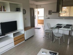 a living room with a television and a table and chairs at Va Pilar in Pilar