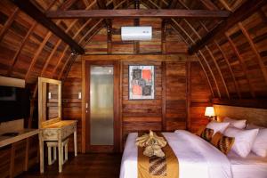 een slaapkamer met een bed in een houten hut bij Poedja Villa Jimbaran in Jimbaran