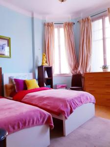 a bedroom with two beds with pink sheets and windows at Home for 2 few steps from casino monte carlo and beach in Beausoleil