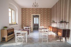 un comedor con mesas, sillas y un piano en B&B Giardino Di Pietra, en Ragusa