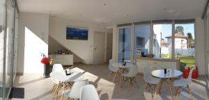 a living room with two tables and white chairs at Crystal B&B in Dormelletto