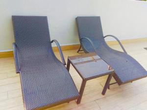 2 blaue Stühle und ein Tisch in einem Zimmer in der Unterkunft The Sentinel Residences Suite in Manila
