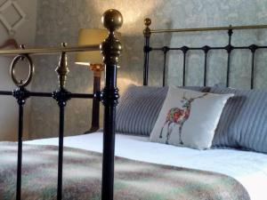 a bed with a black frame and a white pillow at Castle Street Cottage in Ruthin
