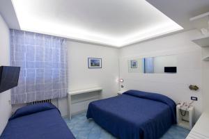 ein Schlafzimmer mit zwei Betten und einem Fenster in der Unterkunft Hotel Il Faro in Sorrent + 47 Fotos