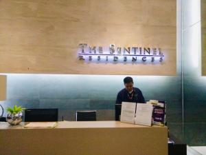 a man standing behind a counter in an office at The Sentinel Residences Suite in Manila