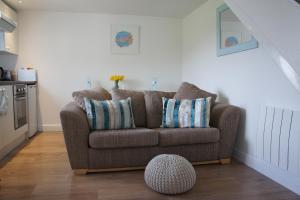 a living room with a brown couch and a table at The annex, Ruthvose in Saint Columb Major