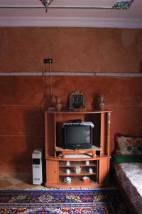TV en un soporte de madera en la sala de estar en Maison berbère, en Ouarzazate