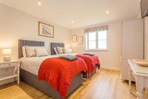 ein Schlafzimmer mit einem Bett mit einer roten Decke darauf in der Unterkunft Briary Cottages at Iletts Farm in Brackley