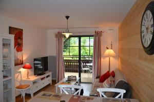 a living room with a clock on the wall at Le Petit Verger 104 in Saint-Lary-Soulan
