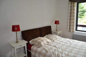 a bedroom with a bed with two night stands and two lamps at Le Petit Verger 104 in Saint-Lary-Soulan