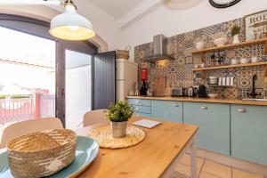 a kitchen with blue cabinets and a wooden table at FARO DOWNTOWN STUDIOS in Faro