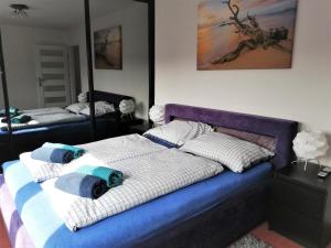 a bedroom with two beds with blue and white pillows at Apartament Morski Integro in Sopot