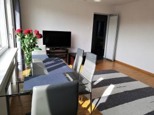 a living room with a glass table and a television at Apartament Morski Integro in Sopot