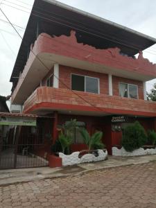 un edificio di mattoni rossi con un incidente di Hostal Cattleya a Puerto Baquerizo Moreno