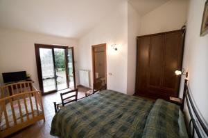 Un dormitorio con una cama y una puerta corrediza de vidrio. en Agriturismo La Piantata, en Bolsena