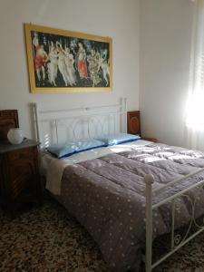 アスティにあるOasi di tranquillitàのベッドルーム1室(ベッド1台付)が備わります。壁には絵画が飾られています。