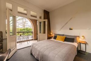 a bedroom with a bed and a balcony at Boutique Hotel Het Scheepshuys in Breda