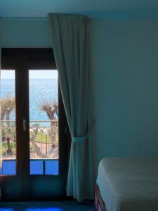 a bedroom with a window with a view of the ocean at Hotel Pisacane in Sapri
