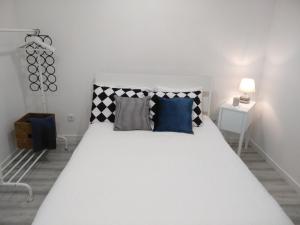 a bedroom with a white bed with blue pillows at Casas do Pedro T3 in Vila Praia de Âncora