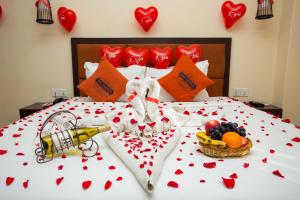 Una cama con corazones rojos en ella con una cesta de fruta en Hotel Jay Suites, en Katmandú