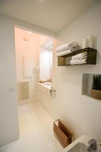 un bagno bianco con lavandino e specchio di Ellie Luxury Apartment a Roma