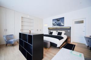 Schlafzimmer mit einem schwarzen und weißen Bett und einem Schreibtisch in der Unterkunft B&B Suites 124 in Brüssel
