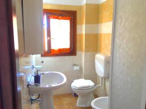 a bathroom with a sink and a toilet and a window at Monolocale Italia in Tergu