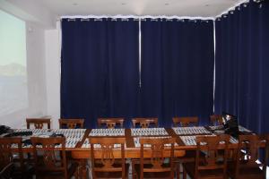 a long table and chairs in front of a blue curtain at Andoni's House in Pitrofós +159 photos