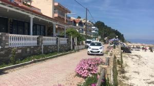 un coche blanco estacionado al lado de una calle en Seaside apartment,just on the beach, unique view, en Kallithea Halkidikis