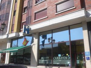 ein Geschäft mit großen Fenstern auf einer Stadtstraße in der Unterkunft Hotel Carbayon in Oviedo