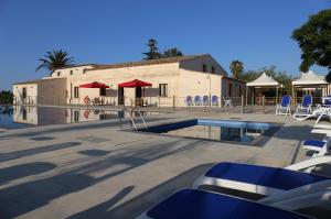 una piscina con sillas y mesas y un edificio en Case Vacanza SANT'AGOSTINO Siracusa, en Siracusa