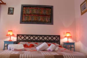 a bedroom with a bed with two lamps on two tables at B&B Su Nuraghe in SantʼAntìoco