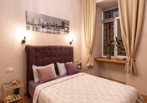 - une chambre avec un grand lit et une fenêtre dans l'établissement Тихие апартаменты недалеко от Дерибасовской, à Odessa