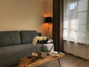 ein Wohnzimmer mit einem Sofa und einem Tisch mit Blumen in der Unterkunft Fewo Zur Goldenen Traube in Rüdesheim am Rhein
