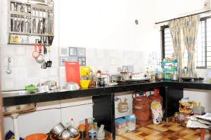 a cluttered kitchen with a black counter top at Single Bedroom to rent in Two bedroom apartment in Udupi