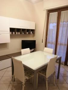 cocina con mesa blanca y sillas en la casa di fiore, en Asti