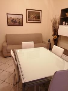 sala de estar con mesa blanca y sofá en la casa di fiore, en Asti