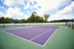 einen Tennisplatz mit zwei Tennisnetzen darauf in der Unterkunft Le Stelsia Resort in Saint-Sylvestre-sur-Lot