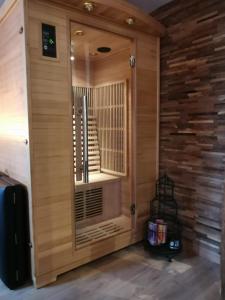 オンフルールにあるLe sauna de l'homme de Bois by Naturogiteの窓付きの木製ドアが備わる客室です。