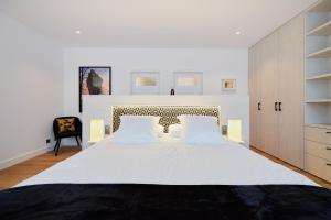 una camera con un grande letto bianco e una sedia di B&B Suites 124 a Bruxelles