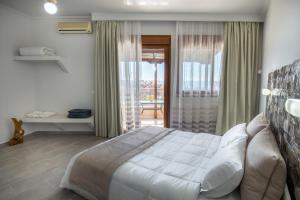 a bedroom with a large bed and a balcony at Villa Oasis in Limenaria