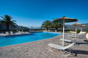 a swimming pool with chairs and umbrellas and a swimming pool at Chrissa Camping Rooms & Bungalows in Delfoi