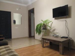 - un salon avec une table et une télévision murale dans l'établissement Apartment Mandarina, à Kobuleti